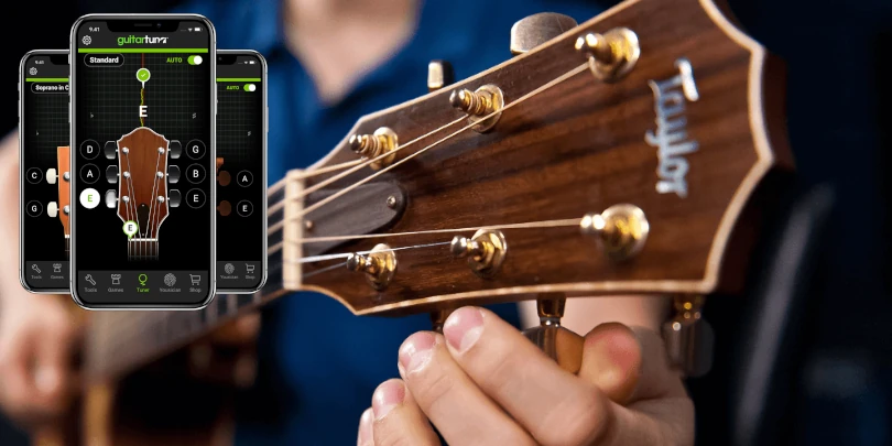 A musician's hand carefully adjusting the tuning pegs of an acoustic guitar, as a smartphone app displays the guitar's tuning status. The guitar is shown in close-up, with a warm, natural lighting that highlights the wood grain and metallic hardware. The app's interface is clean and intuitive, guiding the user through the tuning process. The scene conveys a sense of focus and precision, reflecting the section title "How the App Works."