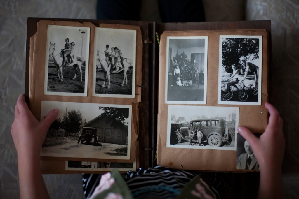 person opening photo album displaying grayscale photos — Foto por Laura Fuhrman na Unsplash